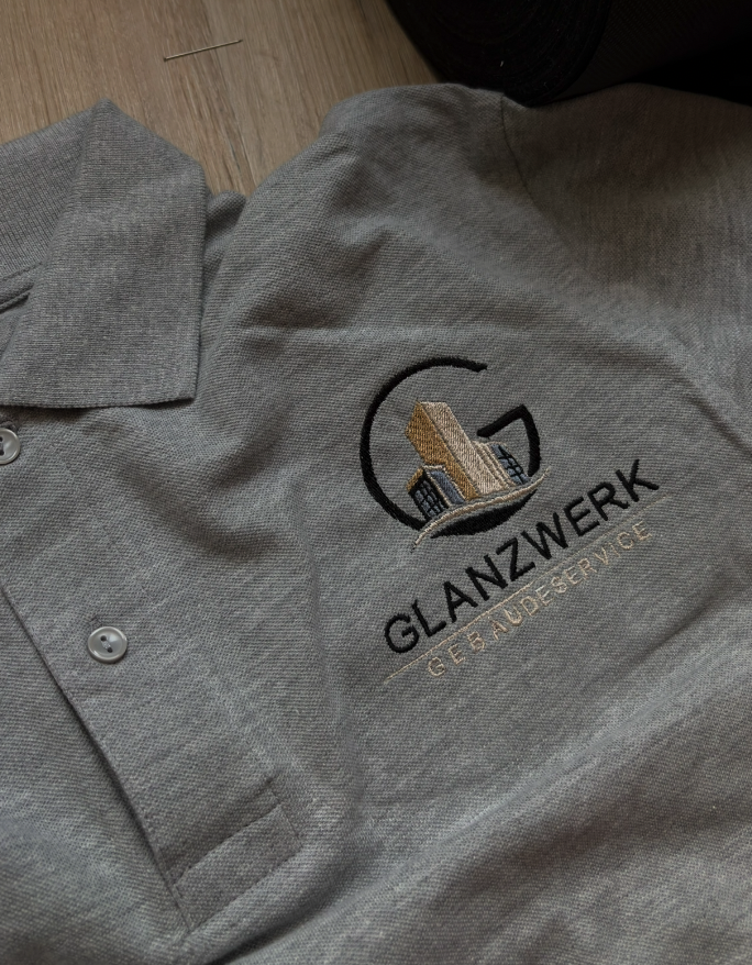 Graues Poloshirt mit gestickter Glanzwerk Gebäudeservice Logo-Stickerei